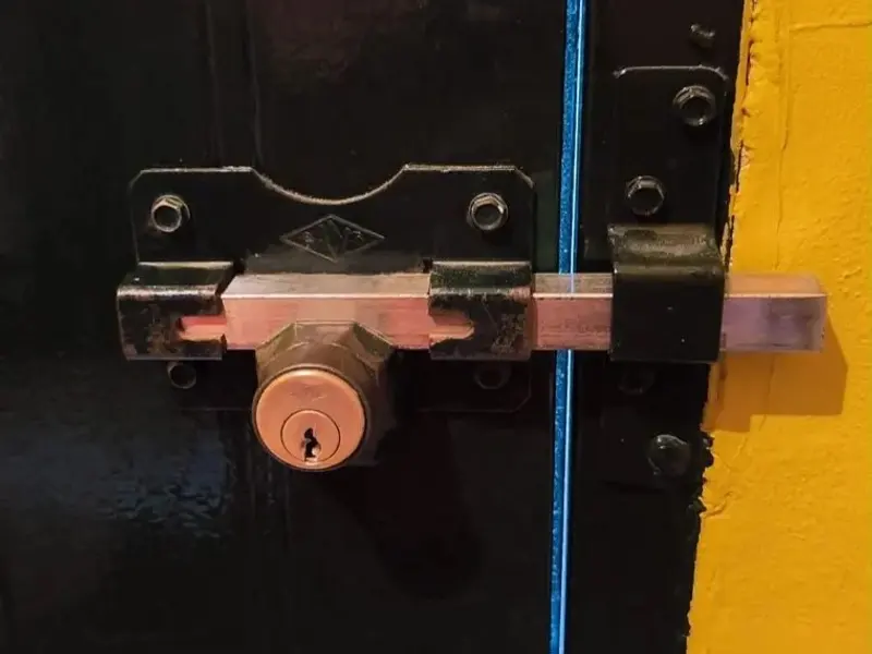 Cerrojo de seguridad con bombín en una puerta metálica