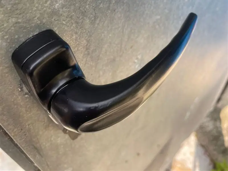 Manilla negra instalada en una puerta metálica